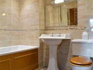 a bathroom with a sink and a toilet and a mirror at Willow Cottage in Ambleside