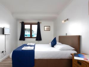 a bedroom with a bed with blue and white sheets at Coot in Wroxham