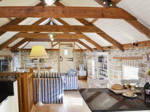 a kitchen and living room with a stone wall at The Stables By The Sea in Newquay