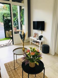 Una sala de estar con una mesa con flores. en Studio port santa lucia, en Saint-Raphaël