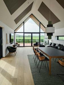 een eetkamer met een grote tafel en stoelen bij Modern Villa By Ballen Marina On Samsø in Ballen