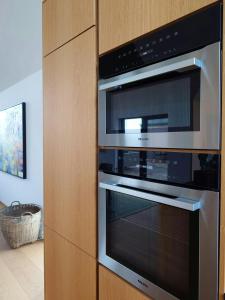 een keuken met twee ovens in een houten kast bij Modern Villa By Ballen Marina On Samsø in Ballen +19 foto's