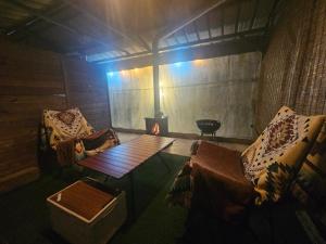 a room with two chairs and a table and a stove at Danyang Kotdle Moolgam Chatki Pension in Nŭt'i