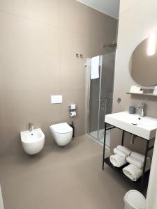 a bathroom with a toilet and a sink and a shower at B&B Margherita Lido Marini in Lido Marini