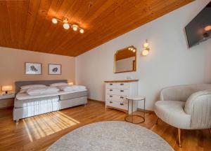 a bedroom with a bed and a couch and a chair at Aparthaus Bianca in Gaschurn