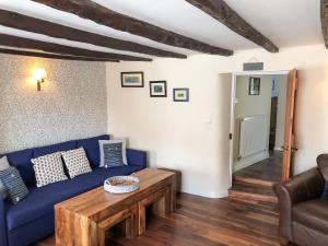 a living room with a blue couch and a table at Church View Cottage & Barn in Hatherleigh