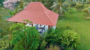 a small house with a red roof in a garden at Welpalla Signature in Welpalla