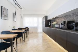 a restaurant with tables and chairs and a kitchen at Talìa Rooms And Gallery in Messina
