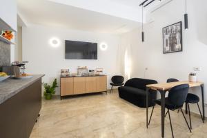 a kitchen and living room with a table and chairs at Talìa Rooms And Gallery in Messina +24 photos