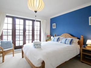 a bedroom with blue walls and a large bed at Spinnakers in Falmouth