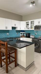 a kitchen with white cabinets and a black counter top at Blue horizon in La Mercy