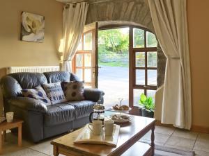 a living room with a couch and a table at The Stables- Osb in Penbryn
