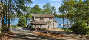 a house with a driveway in front of a lake at Dockside Dream – Your Perfect Waterfront Escape in Lexington