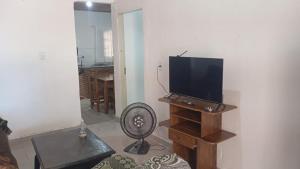 ein Wohnzimmer mit einem Flachbild-TV und einem Ventilator in der Unterkunft Casa quase frente a Rodoviária in Corumbá