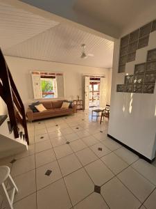 a living room with a couch and a tile floor at Casa com piscina no Cond Canto do Sol - Jacuípe - Guarajuba in Camaçari +24 photos