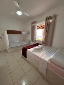 a bedroom with a bed and a window in it at Casa com piscina no Cond Canto do Sol - Jacuípe - Guarajuba in Camaçari