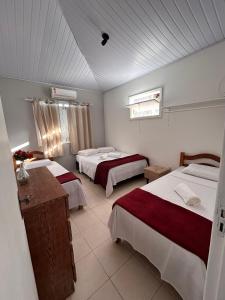 a hotel room with two beds and a window at Casa 10 com piscina em Jacuípe - Guarajuba in Camaçari +22 photos
