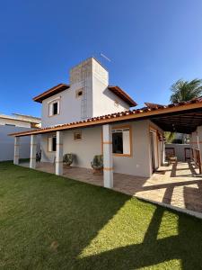 a house with a lawn in front of it at Casa com piscina no Cond Canto do Sol - Jacuípe - Guarajuba in Camaçari