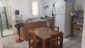 eine Küche mit einem Holztisch und einem weißen Kühlschrank in der Unterkunft Casa quase frente a Rodoviária in Corumbá