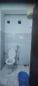 a bathroom with a toilet and a blue bucket at Hotel RUMTEK in Gangtok