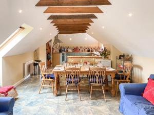 a kitchen and dining room with a wooden table and chairs at Fairlaw Garden Cottage in Reston
