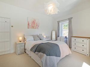 ein weißes Schlafzimmer mit einem Bett und einem Fenster in der Unterkunft Duck Cottage in Gargrave