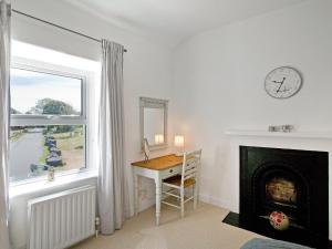 Zimmer mit einem Schreibtisch, einem Fenster und einer Uhr in der Unterkunft Duck Cottage in Gargrave + 8 Fotos