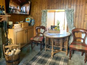 ein Raum mit einem Tisch und zwei Stühlen und einem Fenster in der Unterkunft Mains Of Auchmedden Cottage in Pennan