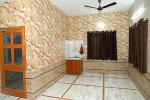 une pièce avec un mur en pierre et un ventilateur de plafond dans l'établissement Eagle farmstay, à Pushkar