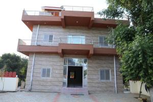 un bâtiment avec un balcon au-dessus dans l'établissement Eagle farmstay, à Pushkar 20 autres photos