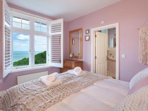 ein Schlafzimmer mit einem großen Bett mit zwei Handtüchern darauf in der Unterkunft Haven Heights in Martinhoe