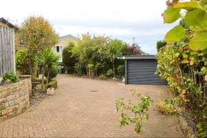 une allée en briques avec un garage dans une cour dans l'établissement Home in West Yorkshire with driveway and 3 double bedrooms - sleeps 6!, à Thornhill