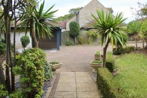 un jardin avec des palmiers et une allée dans l'établissement Home in West Yorkshire with driveway and 3 double bedrooms - sleeps 6!, à Thornhill