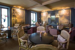 a restaurant with tables and chairs and paintings on the walls at Hotel d'Europe in Avignon