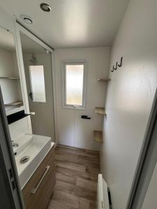 a bathroom with a sink and a mirror at Mobil-home 565 tout confort camping SIBLU 4 étoiles in Gastes