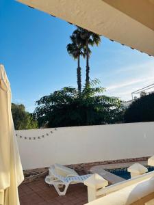 a view of a palm tree on a white wall at Villa Limon Playa Flamenca in Alicante