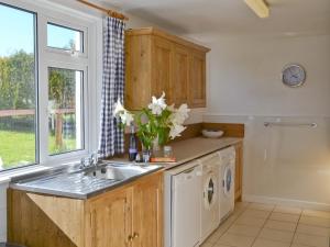 eine Küche mit Spüle und Waschmaschine in der Unterkunft Granny Bond's Farmhouse in Buckland Brewer