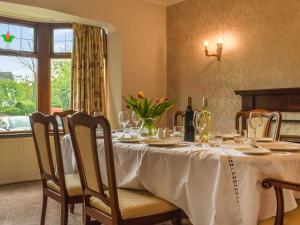 einen Esstisch mit Weingläsern und ein Fenster in der Unterkunft Melrose in Clitheroe