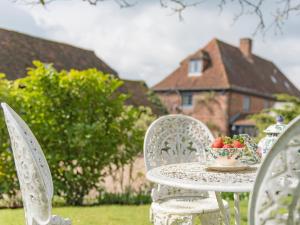 a white table with a bowl of fruit on it at Woolhouse Barn in Hunton