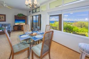 a dining room with a table and chairs and a window at 412 Ridge in Kahana