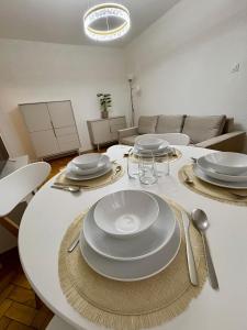 a white table with plates and silverware on it at MW Leo Apartament in Konin