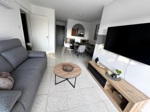 un salon avec un canapé et une télévision à écran plat dans l'établissement Coral Bay Star - Direct sea location, à Peyia