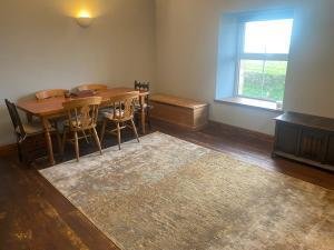 a dining room with a table and chairs and a window at The Sennen View in Sennen