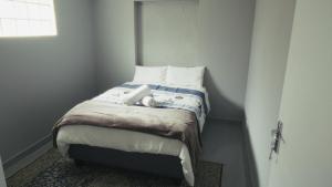 a small bedroom with a bed with white pillows at Halaal Serenity 3bedroom 6sleeper in Cape Town