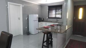 a kitchen with a white refrigerator and a counter at Halaal Serenity 3bedroom 6sleeper in Cape Town +16 photos