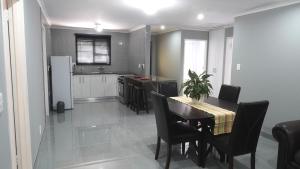 a kitchen and dining room with a table and chairs at Halaal Serenity 3bedroom 6sleeper in Cape Town