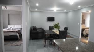 a bedroom with a bed and a dining room with a table at Halaal Serenity 3bedroom 6sleeper in Cape Town