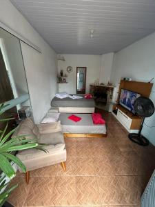 a bedroom with two beds and a couch in it at Casa da Nise in São Gabriel