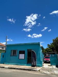 a blue building with a surfboard in front of it at Casa da Nise in São Gabriel