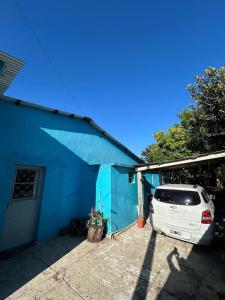 a white car parked in front of a blue house at Casa da Nise in São Gabriel +1 photo